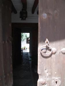 a wooden door with a ring on it in a hallway at La Casa de Corruco in Casabermeja