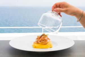 a person pouring a glass over a piece of food on a plate at Dimora Talenti in Polignano a Mare