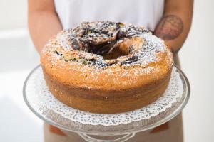 a person holding a bundt cake on a plate at Dimora Talenti in Polignano a Mare