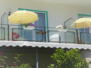 three umbrellas on a balcony with flowers in pots at Villa Rauter in Seeboden