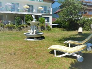 a park with a fountain and two chairs and a bench at Villa Rauter in Seeboden