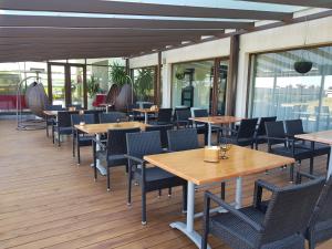 a row of tables and chairs on a patio at Rezidencija Grįžulo ratai in Sasnava