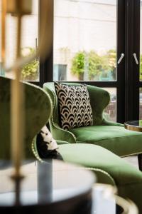 eine grüne Couch vor einem Fenster in der Unterkunft C-Hotels Continental in De Panne