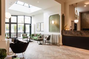 a lobby with chairs and tables in a building at C-Hotels Continental in De Panne