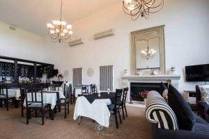une salle à manger avec des tables, des chaises et une cheminée dans l'établissement The Lodge at Atlantic Beach, à Melkbosstrand