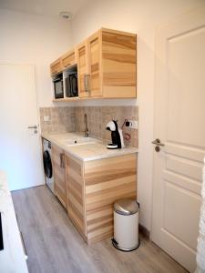 una piccola cucina con armadi in legno e lavandino di Comédie ST-Roch - Studio - Hypercentre Gare - CLIM & NETFLIX a Montpellier