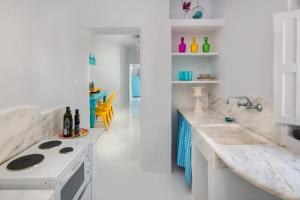 a white kitchen with a stove and a sink at Barocco Bello Villa in Fira +20 photos