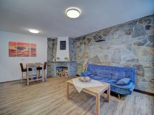 ein Wohnzimmer mit einer blauen Couch und einer Steinwand in der Unterkunft Gästehaus Eschbach in Monschau