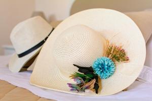 un cappello di paglia bianca con un fiore blu sopra di Agriturismo Il Megalite a Giurdignano
