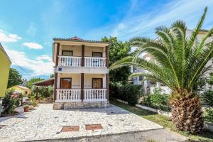 ein Haus mit einem Balkon und einer Palme in der Unterkunft Medulin Riviera Apartments Goran in Medulin