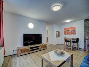 ein Wohnzimmer mit Flachbildfernseher und Tisch in der Unterkunft Gästehaus Eschbach in Monschau