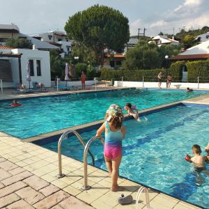 młoda dziewczyna stojąca w wodzie przy basenie w obiekcie Oikismos Trikorfou w mieście Gerakini