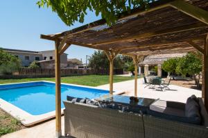 une terrasse avec une pergola en bois et une piscine dans l'établissement Villa Valls, à Montuiri