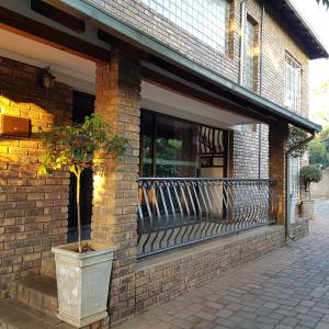Pretoria的住宿－Falling Feather Inn，砖砌建筑,带有种有盆栽植物的阳台