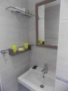 a white bathroom with a sink and a mirror at Villa VAYA in Villemoustaussou