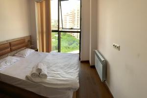 a bedroom with a bed with towels on it at City Central Apartment in Yerevan +68 photos