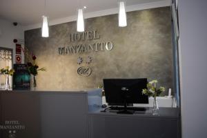 a hotel reception desk with a computer on top of it at Hotel Manzanito in Antequera