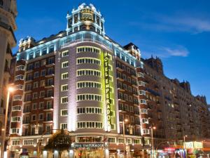 un gran edificio con un letrero de neón. en Emperador, en Madrid