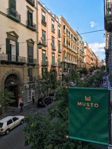 um sinal em frente a uma rua com edifícios em Musto Suites & Rooms em Nápoles