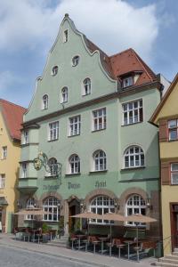 ein großes, grünes Gebäude mit spitzem Dach in der Unterkunft Hotel PIAZZA in Dinkelsbühl