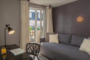فندق أوبرا ماريجني في باريس: غرفة معيشة مع أريكة وطاولة