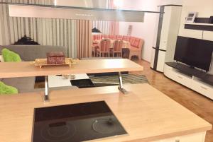 ein Wohnzimmer mit einem Sofa, einem TV und einem Tisch in der Unterkunft Big Und Bequem in Hannover