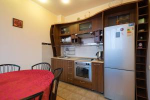 a kitchen with a white refrigerator and a table at Nadezhda Apartments in Keremet Microdistrict in Almaty