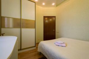 a room with a bed with a mirror and a door at Nadezhda Apartments on Keremet in Almaty