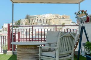 a chair and a table on a balcony with a view at Naxos Center Houses in Naxos Chora