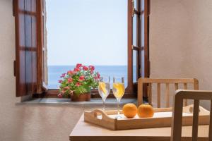 uma mesa com dois copos de vinho e laranjas em Casa Rodanthi - Luxury Castle Residence em Monemvasia