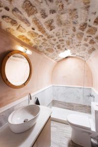 a bathroom with a sink and a toilet and a mirror at Casa Rodanthi - Luxury Castle Residence in Monemvasia