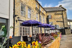 a table with purple umbrellas in front of a building at The George Hotel in Axminster