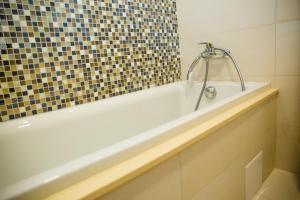 a white bath tub with a shower in a bathroom at Apartament Calea Bucuresti in Piteşti