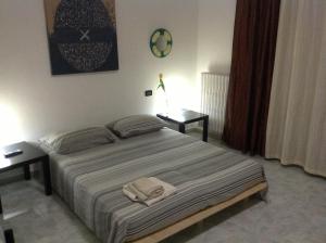 1 dormitorio con 1 cama con 2 mesas y 2 toallas en Appartahotelpuglia Gruppo Albergo Lamanna, en Taranto