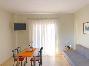 a dining room with a table and chairs and a window at Red Coral Apartments in Vatopedi