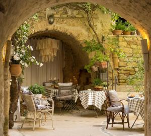 un patio con un arco, arredato con tavolo e sedie. di La Cordière a Lourmarin