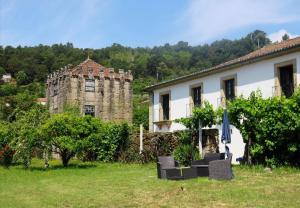 an old stone building next to a house at Casa da Eira in Cabeceiras de Basto