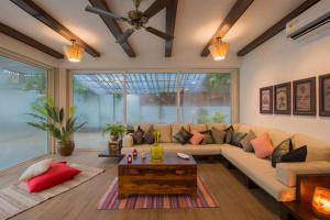 sala de estar con sofá y mesa en EL Lodge by StayVista - Pool, lawn, and a charming gazebo for your perfect getaway en Lonavala