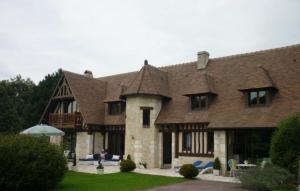 een groot bakstenen huis met een dak bij Hibiscus 1er étage in Honfleur