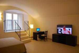 a bedroom with a bed and a television and a staircase at Il Purgatorio in Barletta