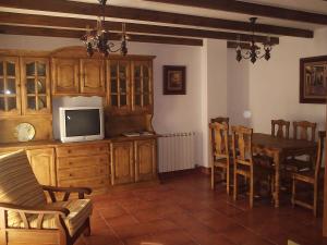 a living room with a television and a dining room table at Casa Rural Arturo I in Sahagún
