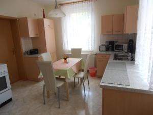 eine Küche mit Tisch und Stühlen und eine Küche mit Spüle in der Unterkunft Ferienwohnung Mitreuter in Wildenau