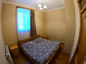 a small bedroom with a bed and a window at Guesthouse Lenjeri in Mestia