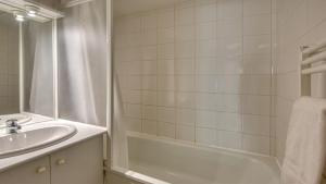 a bathroom with a tub and a sink and a shower at Vacancéole - Residence le Domaine du Bosquet in Égletons +39 photos