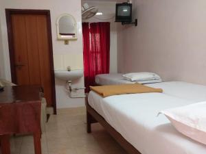 Postel nebo postele na pokoji v ubytování Anandan Tourist Home