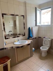 a bathroom with a sink and a toilet and a mirror at Rania House in Limenas