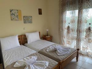 two twin beds in a bedroom with a window at Rania House in Limenas