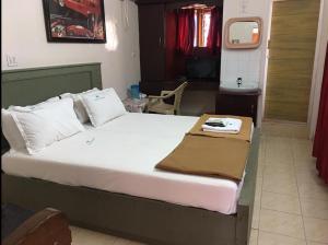a bedroom with a large bed with a table on it at Anandan Tourist Home in Varkala