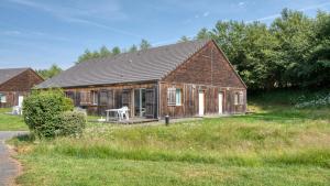 a wooden house with a table in a field at Vacancéole - Residence le Domaine du Bosquet in Égletons