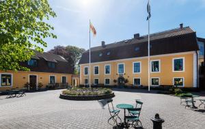 un edificio con un patio con sillas y una fuente en Stiftsgården Åkersberg en Höör